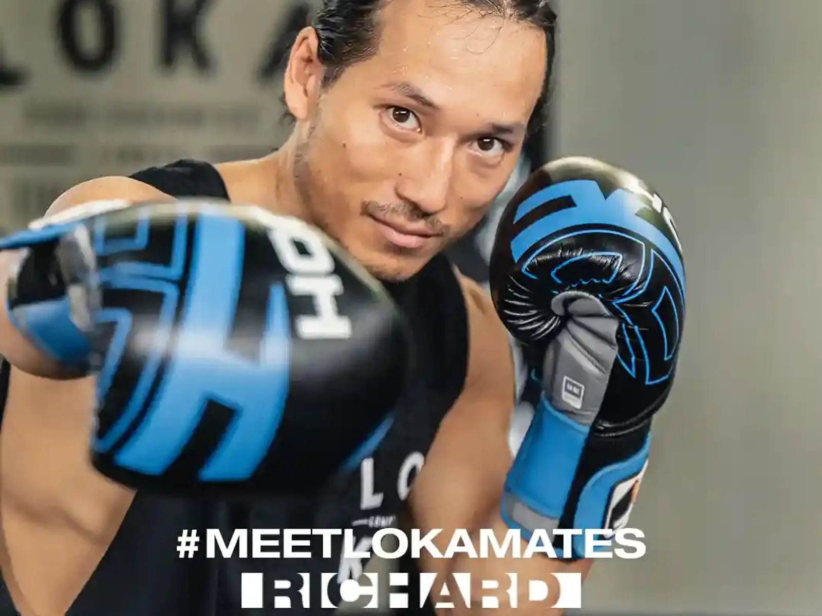 Man with boxing gloves at Loka Gym with #MEETLOKAMATES branding