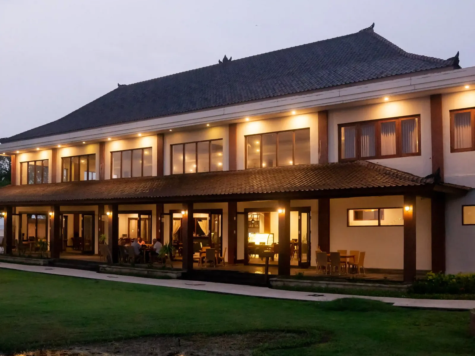 Exterior view of Hotel Ombak Sunset with traditional Indonesian architecture at dusk